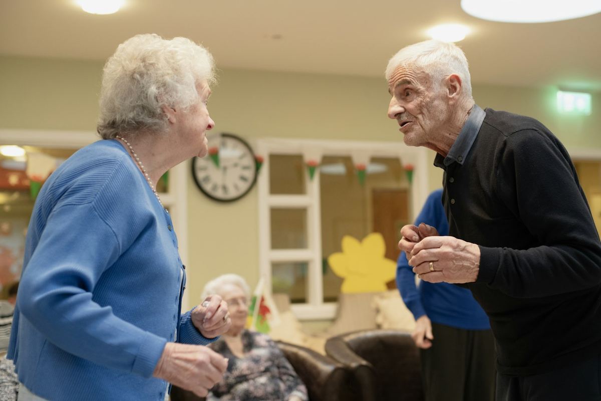 An older couple talking in a bright room